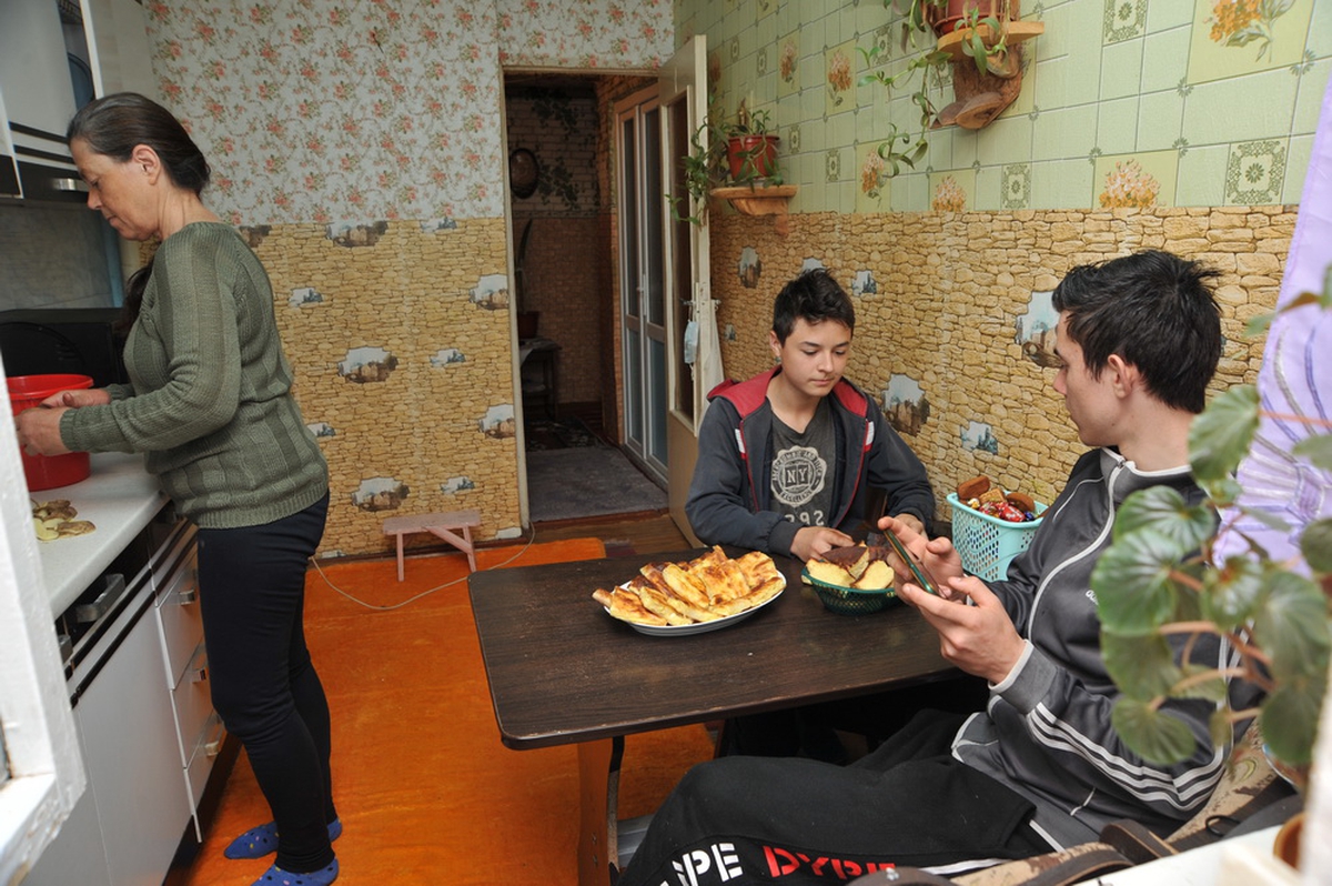 Mother with her two children in the kitchen in Moldova