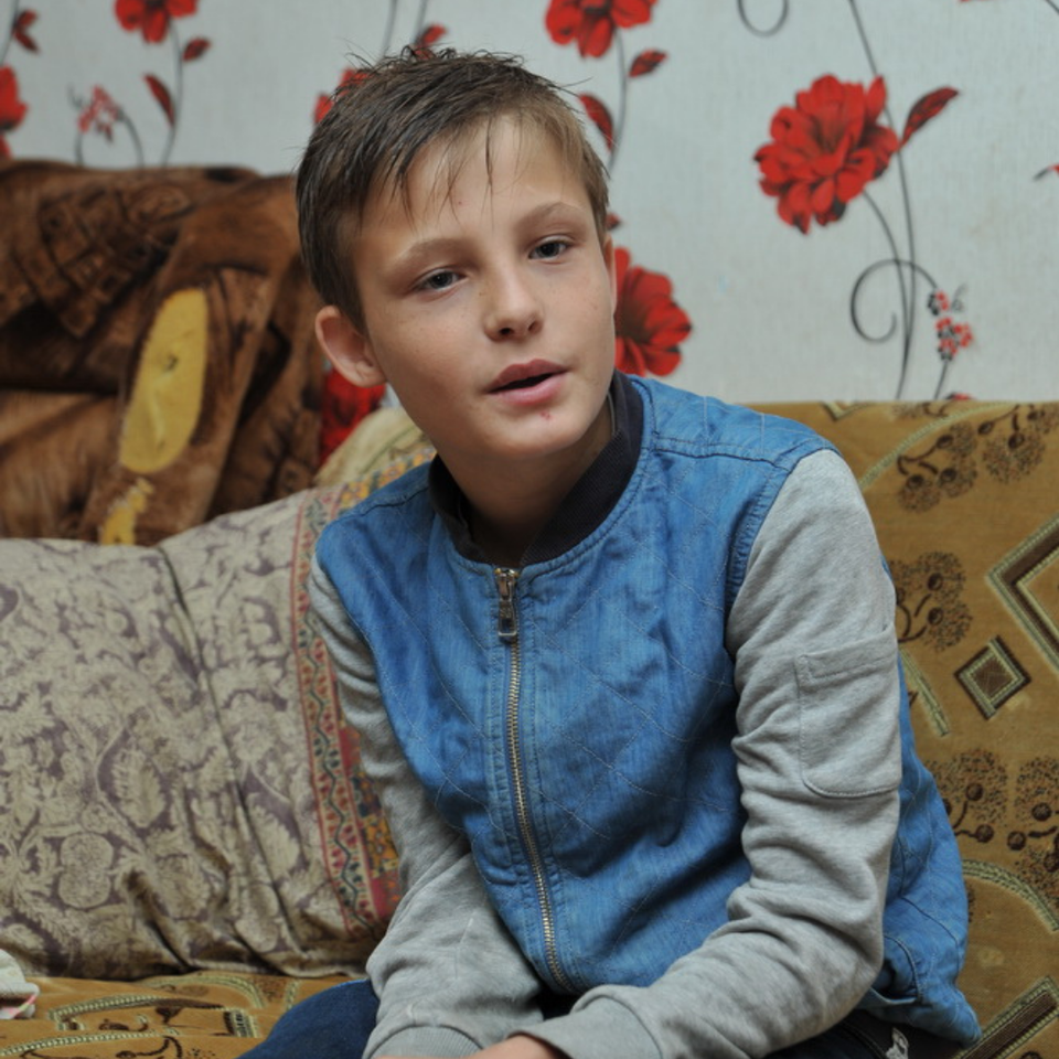 Boy sitting in a lounge room in Moldova